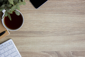 Working space with coffee, computer, notebook and phone on a wooden table. 