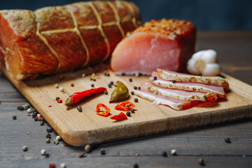 Various types of meat and sausages on wooden table, served on board, closeup