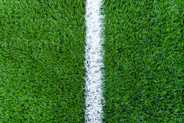Football green field with white line at the middle. Top view closeup.