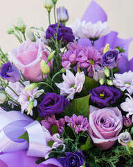 Bouquet of flowers in purple hat box on a light background, close-up, selective focus