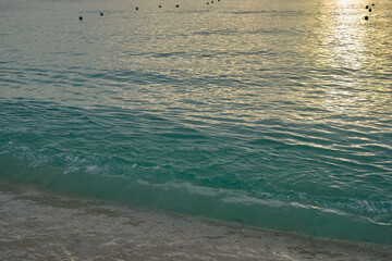 Dusk on the ocean as small waves lap the beach in the Cayman Islands BWI