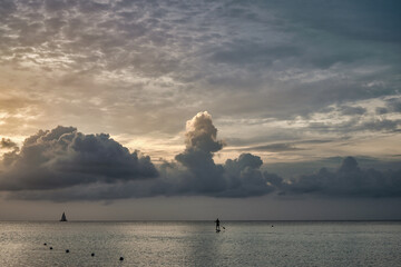 Silhoutte of a paddle boarder headed out at sunset in the Cayman Islands BWI