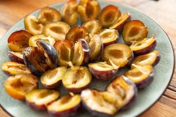  sliced halves of sweet purple plum on a plate