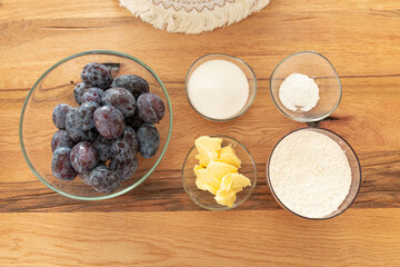 Home cooking baking plum cake with ingredients on wooden table, top view