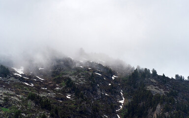 mountain peaks in dense fog and cloud