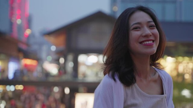 portrait of pretty asian woman looking at camera smile in the urban city street at Chengdu China