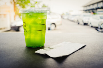 a plastic glass of iced kiwi soda on the concrete or cement table bar in the coffee shop with copy space
