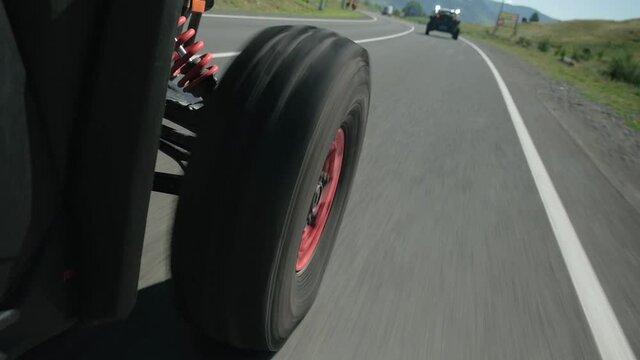 The front wheel of the buggy rides on the highway. Rear side view