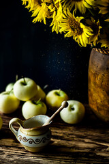 Still life with a bouquet of sunflowers and honey. Flowers and honey in focus
