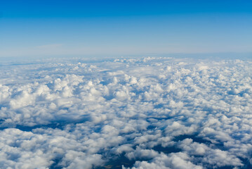 Naklejka na ściany i meble View of the sky above the clouds. blue sky high view from airplane window clouds shapes. sky-clouds background. Above the cloud