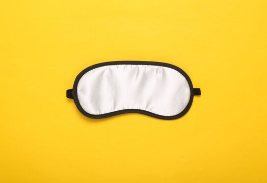 Sleep Mask On Yellow Background. Top View, Flat Lay. Concept Of Vivid Dreams. Accessories For Sleep. Minimal Style.