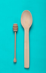 Wooden spoon and honey stick on turquoise background