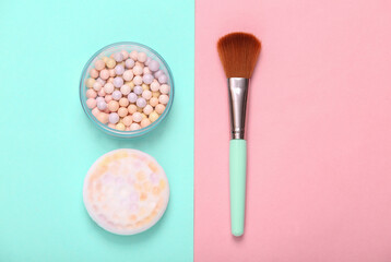 Powder Balls with makeup brush on pink blue background. Cosmetics. Top view