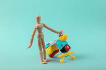 Puppet with an inverted scooter on a blue background. Repair concept, accidend