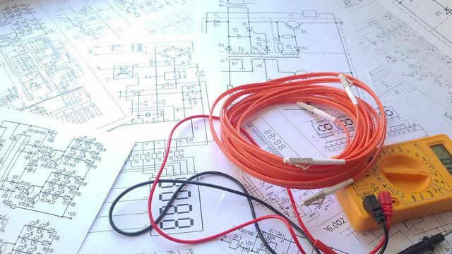 Fiber optic patch cord cable and digital multimeter on electrical engineering drawings