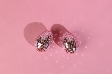 Disco balls, mirror eggs on a pink background