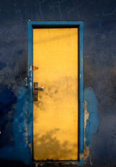 yellow door on blue wall.