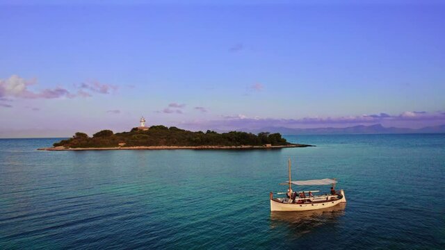Atardecer en barco con isla y faro. Playa, mallorca isla