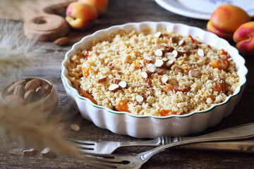 Fresh apricot crumble, almonds dressing in ceramic dish