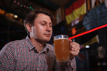 Close up of a mature man smelling delicious craft beer in his glass