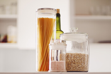 Food products in glass jars in the kitchen, pasta, cereal, salt, wine, groceries.