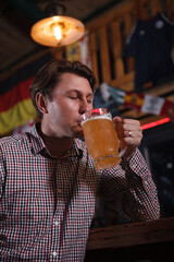 Vertical shot of a man drinking beer at the pub