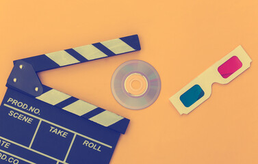 Film clapper board, 3d glasses and cd on yellow background. Cinema industry, entertainment. Top view