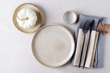 Festive table decoration for Halloween, Thanksgiving. Empty ceramic plates and cutlery