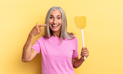 looking excited and surprised pointing to the side and upwards to copy space and holding a fly...