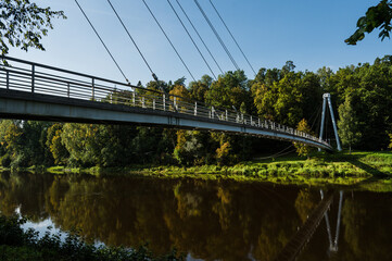 Scenic landscape of river in Gauja national park near Sigulda in Latvia. Modern architecture of bridge.