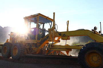 A grader in the process of grading a dirt road