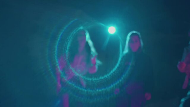 Group of millennials dancing on roller skates in dark studio. Teenagers spending time together freeskating and showing moves, having good time. View on nightlife youth culture. Concept of lifestyle.