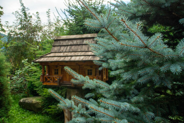 Fir brunches in front of a decorative wooden house