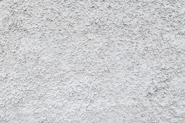 Close-up of a plastered and rough concrete or stone wall painted in white or light gray. High resolution full frame textured background. Copy space.