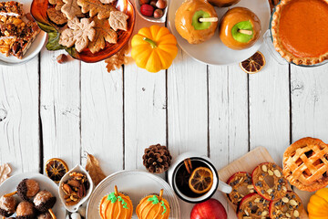 Autumn desserts double border. Table scene with assorted sweet fall treats. Top down view over a white wood background. Copy space.