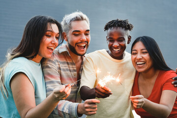Diverse friends having fun celebrating with fireworks - Focus on right hands holding sparklers