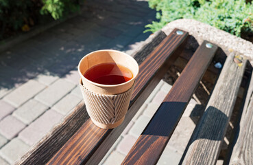 Corrugated paper cup with tea on the street bench