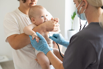 Doctor giving baby girl checkup in doctor office