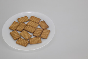 Close up shot of Indian tea biscuits on a white plate and isolated with white background and copy space. Indian tea biscuits popularly known as Chai-biscuit in India