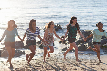 Women holding hands on beach