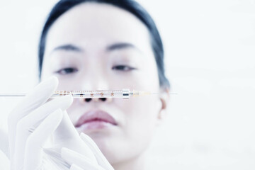 Woman examining syringe