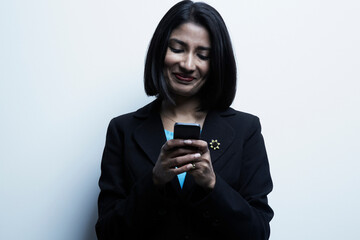 Studio portrait of businesswoman looking at cellphone