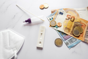 covid-19 rapid test with negative result, utensils, some euro money and a medical ffp2 face mask on...