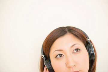 Fototapeta premium Woman wearing earphones looking upward
