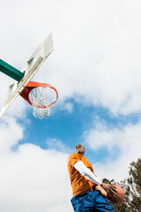 Young man jumping to score hoop in basketball © Image Source Limited