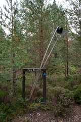 Fire brooms sign with fire beating equipment and forest background. Rothiemurchus wildlife conservation area, Cairngorms National Park in Scotland, UK. No people.