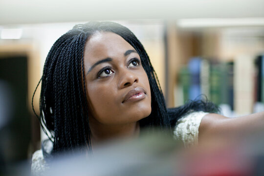 Female student choosing book in library