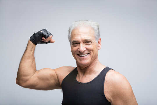 Senior man flexing muscle, portrait