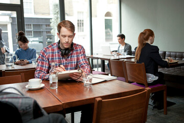 Young man with digital tablet in cafe