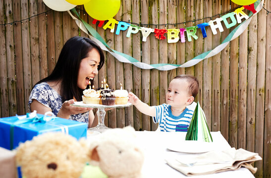 Mother showing cakes to baby boy